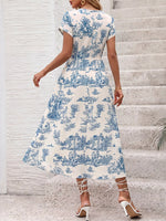 Woman wearing a blue and white patterned dress on stone steps.