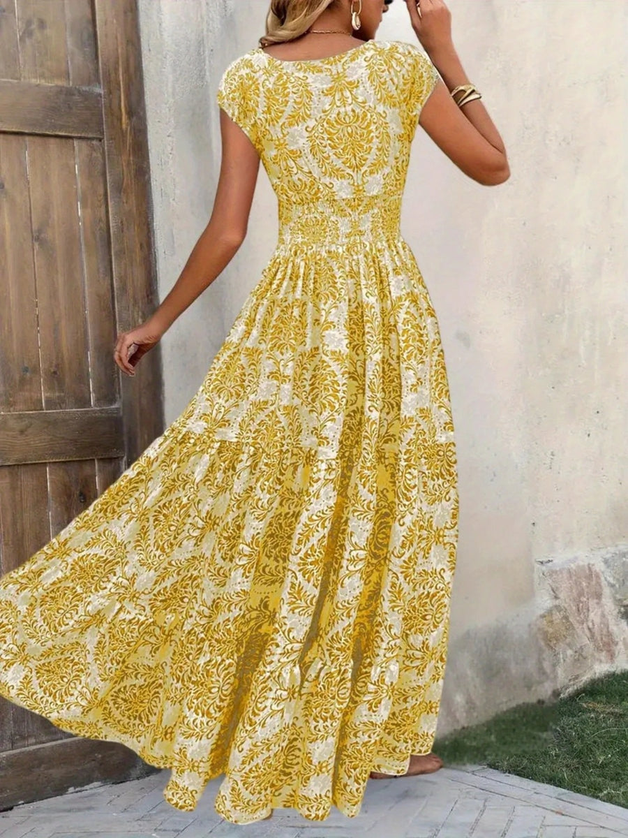 Woman wearing a yellow floral dress against a neutral wall.