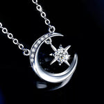 Silver moon and star pendant necklace on a black background