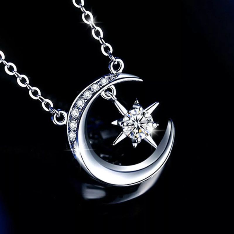 Silver moon and star pendant necklace on a black background