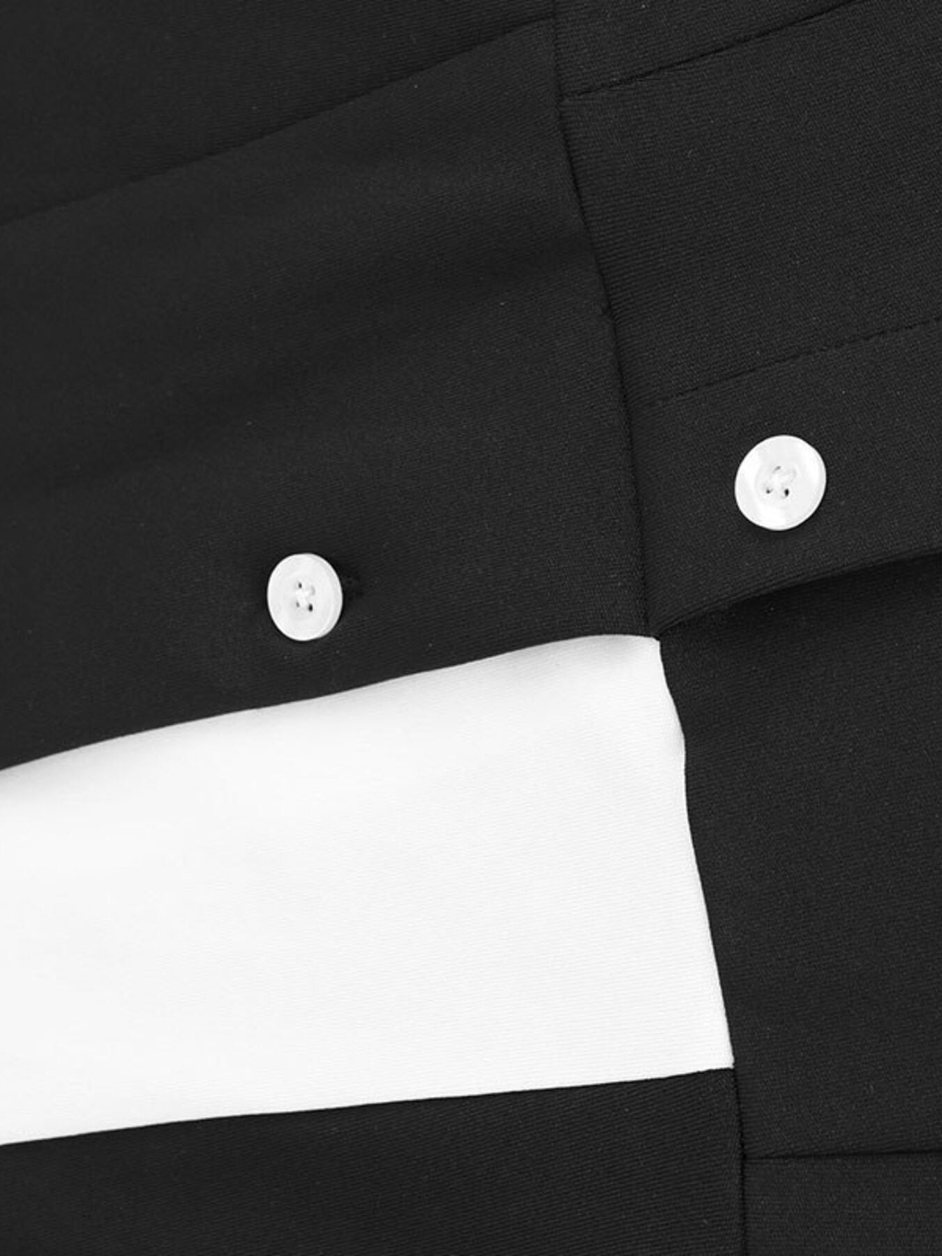 Close-up of a black shirt with white buttons on a white background