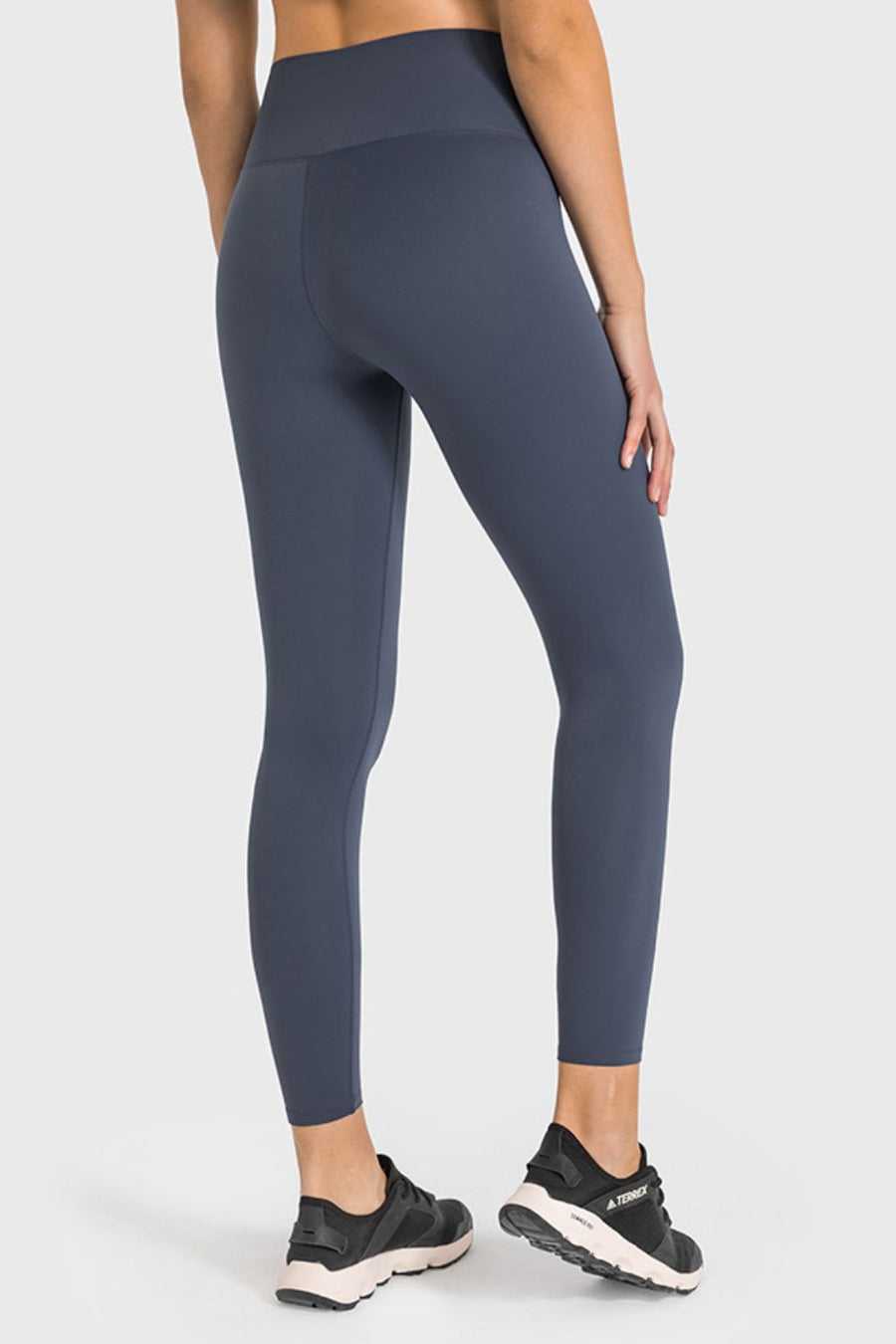 Person wearing dark gray leggings on a white background