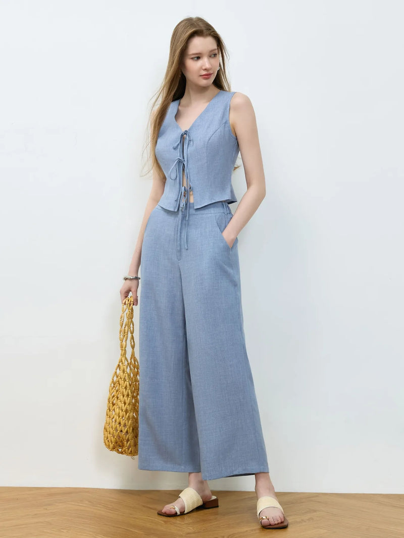 Woman wearing a light blue jumpsuit with a white background
