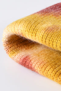 Close-up of a textured fabric with yellow and pink gradient on a white background
