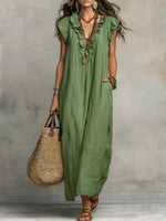 Woman wearing a green dress holding a straw bag against a gray background