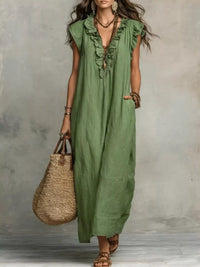 Woman wearing a green dress holding a straw bag against a gray background