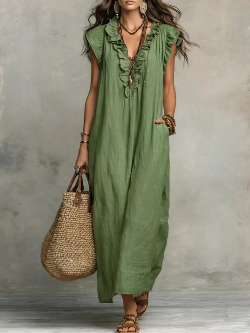 Woman wearing a green dress holding a straw bag against a gray background
