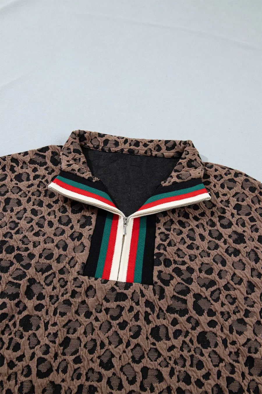 Leopard print jacket with a colorful zipper on a light gray background