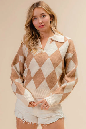 Woman wearing a diamond patterned sweater and shorts against a beige background