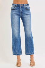 Blue jeans worn by a person on a white background