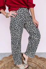 Person wearing red top and leopard print pants on a plain background