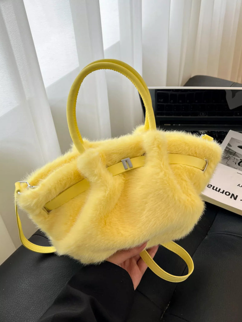 Yellow furry handbag held in front of a blurred indoor background