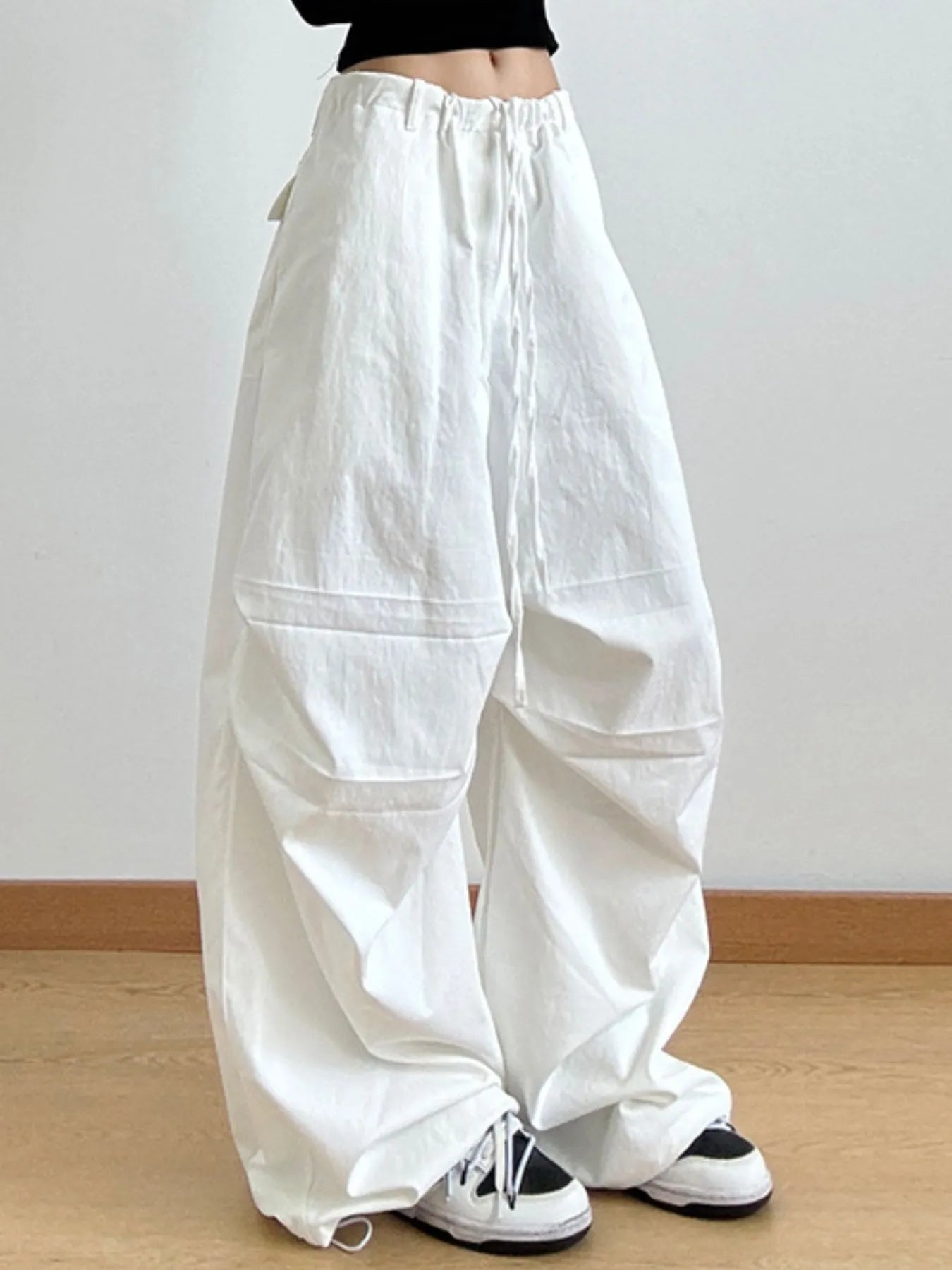 White wide-leg pants worn by a person on a plain background