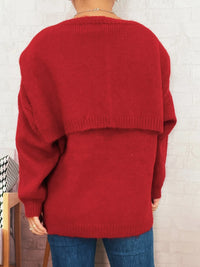 Red sweater worn by a person against a white brick wall.