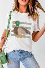 Person wearing a white t-shirt with a duck graphic, holding a green handbag.