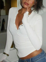 Person wearing a white long-sleeve top and blue jeans indoors.