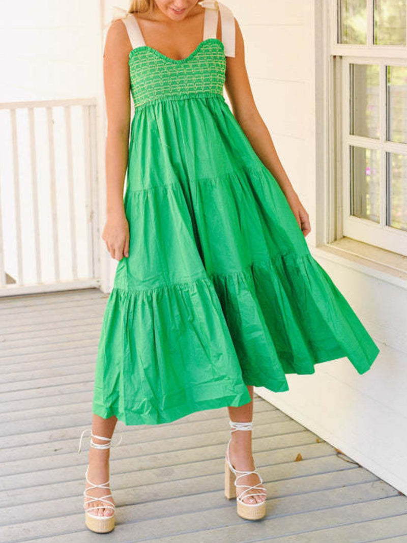 Woman wearing a green dress on a wooden deck.