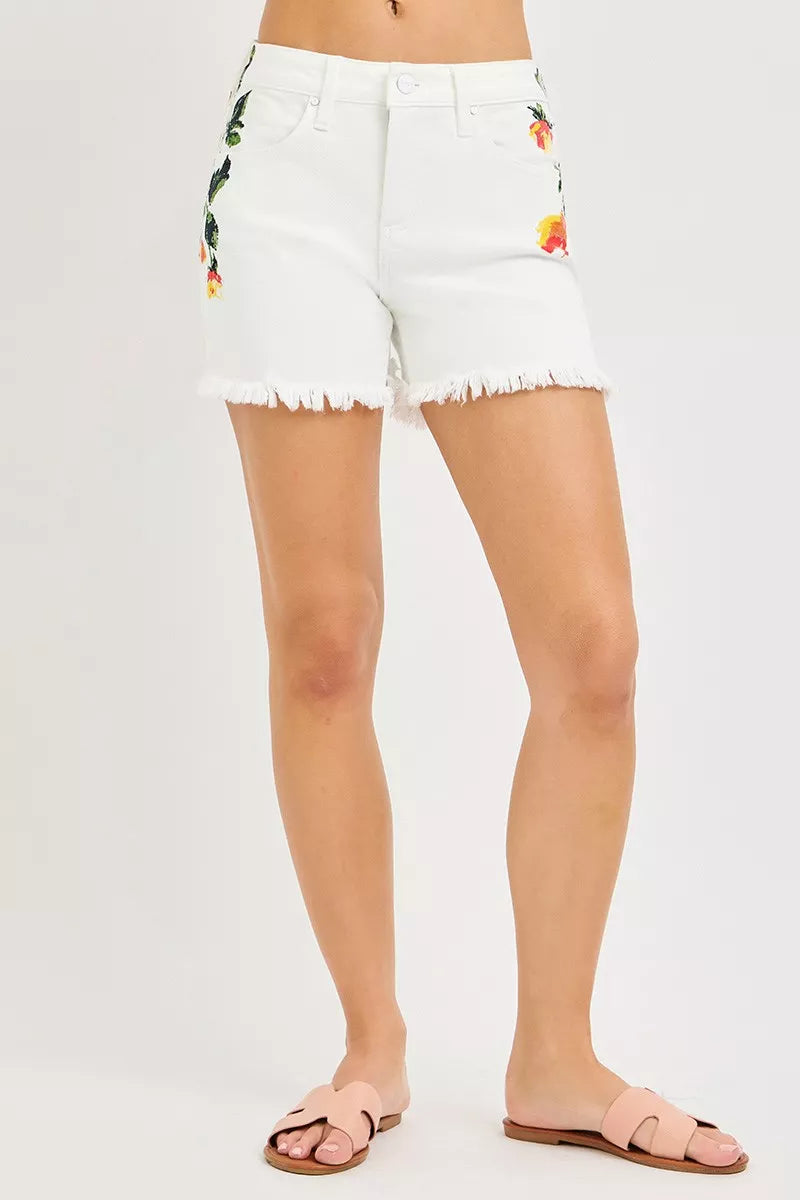White denim shorts with floral embroidery on a white background
