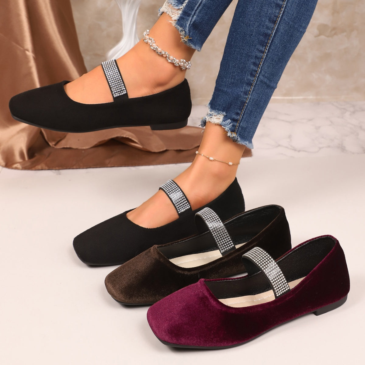 Black, brown, and purple flats with rhinestone straps on a neutral background