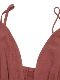 Close-up of a rust-colored top with thin straps on a white background