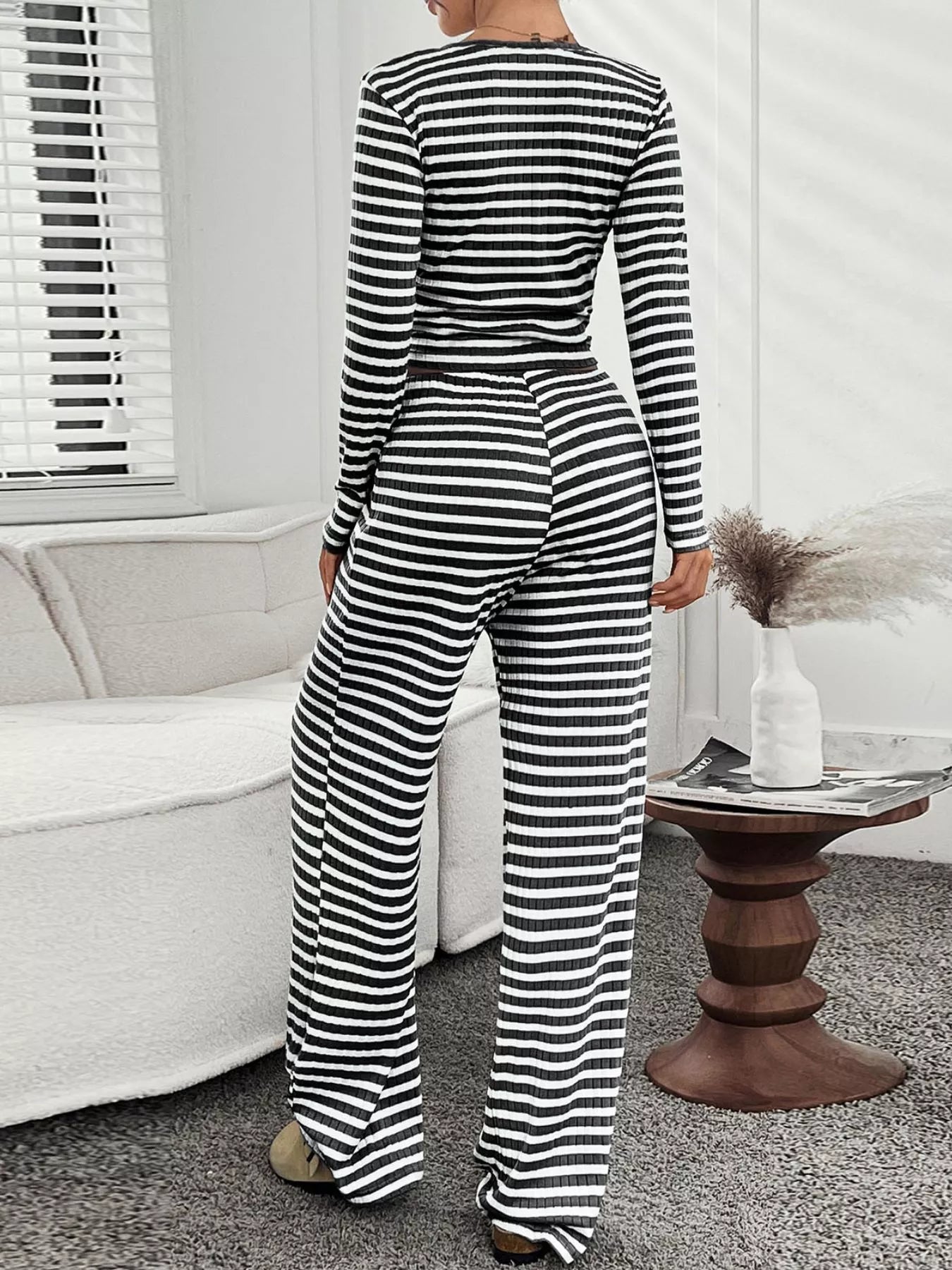Person wearing a black and white striped jumpsuit in a living room setting.