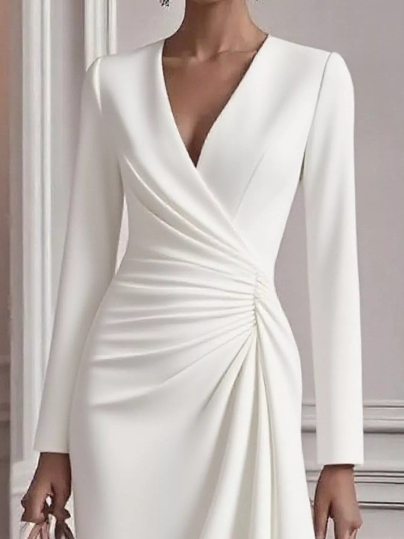 White long-sleeve dress with a V-neckline on a neutral background