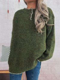 Person wearing a green sweater with a blurred background