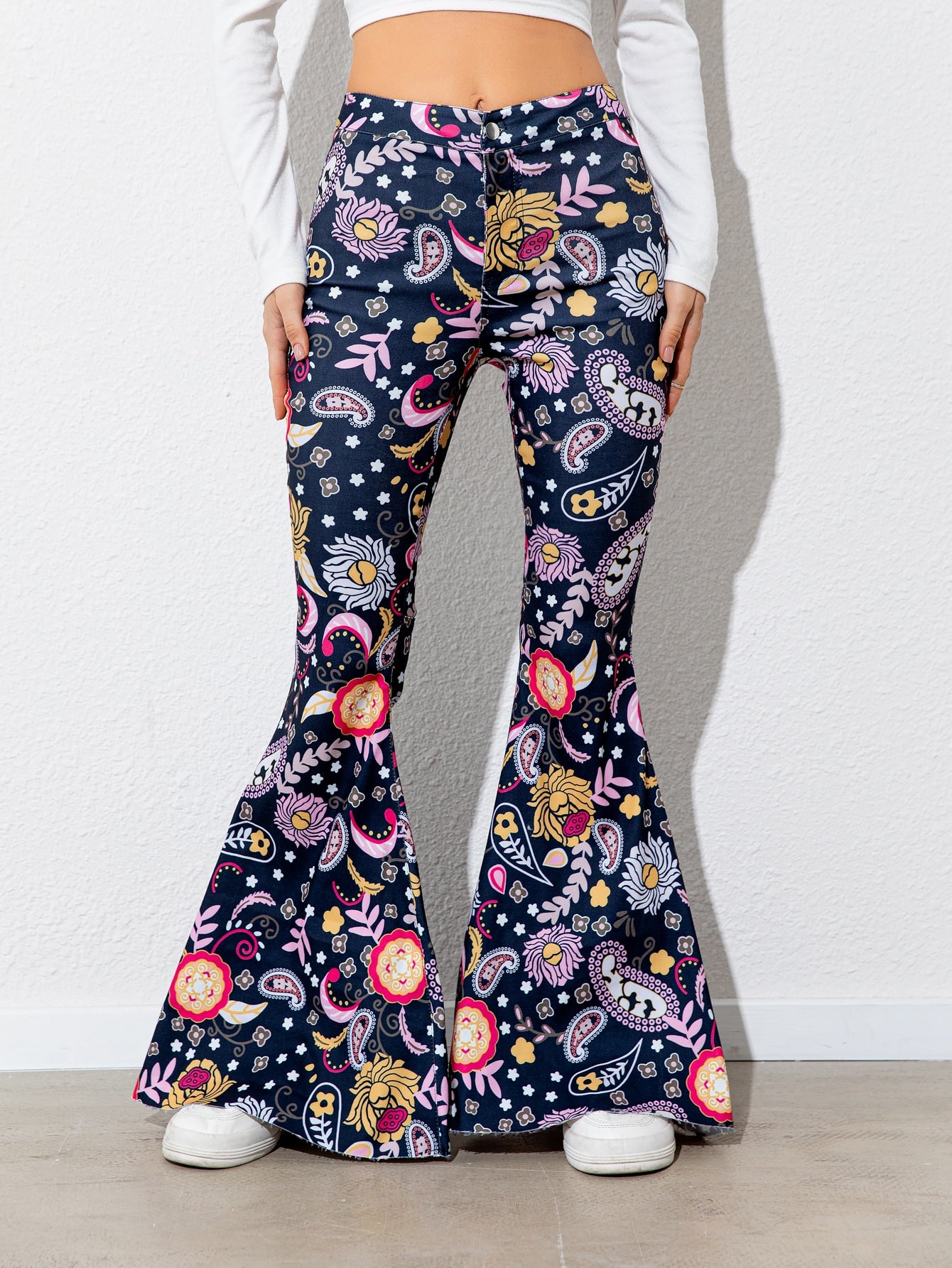 Flared pants with colorful pattern worn by a person on a white background
