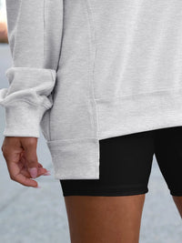 Person wearing a gray sweatshirt and black shorts with a blurred background