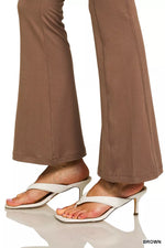 Brown pants worn with white high-heeled sandals on a white background