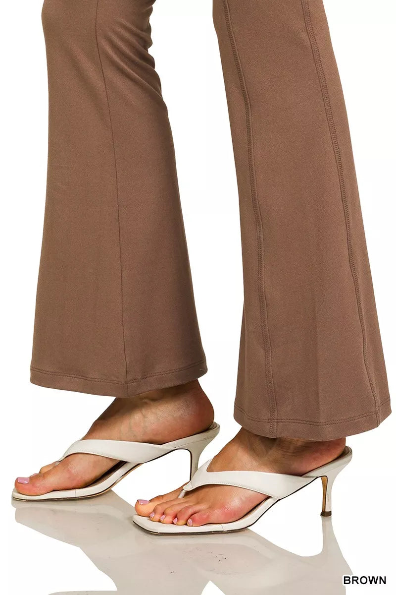 Brown pants worn with white high-heeled sandals on a white background