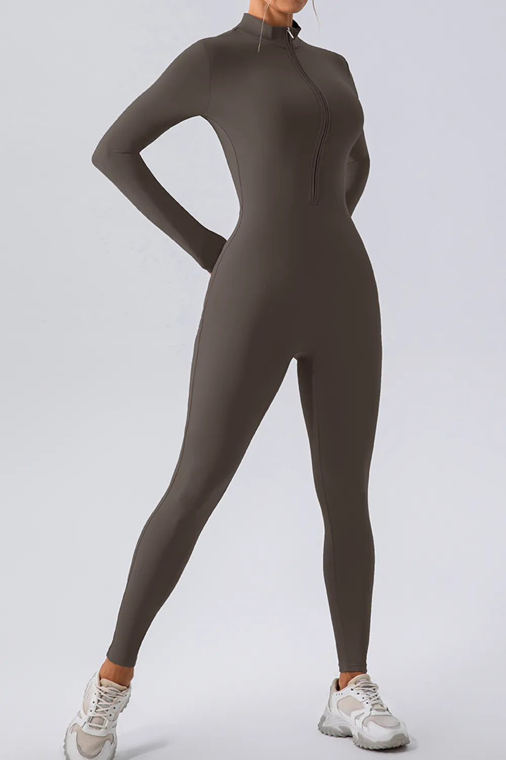 Person wearing a brown full-body suit on a light gray background