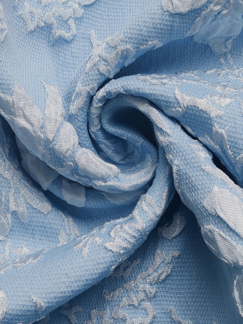 Close-up of blue fabric with white floral embroidery