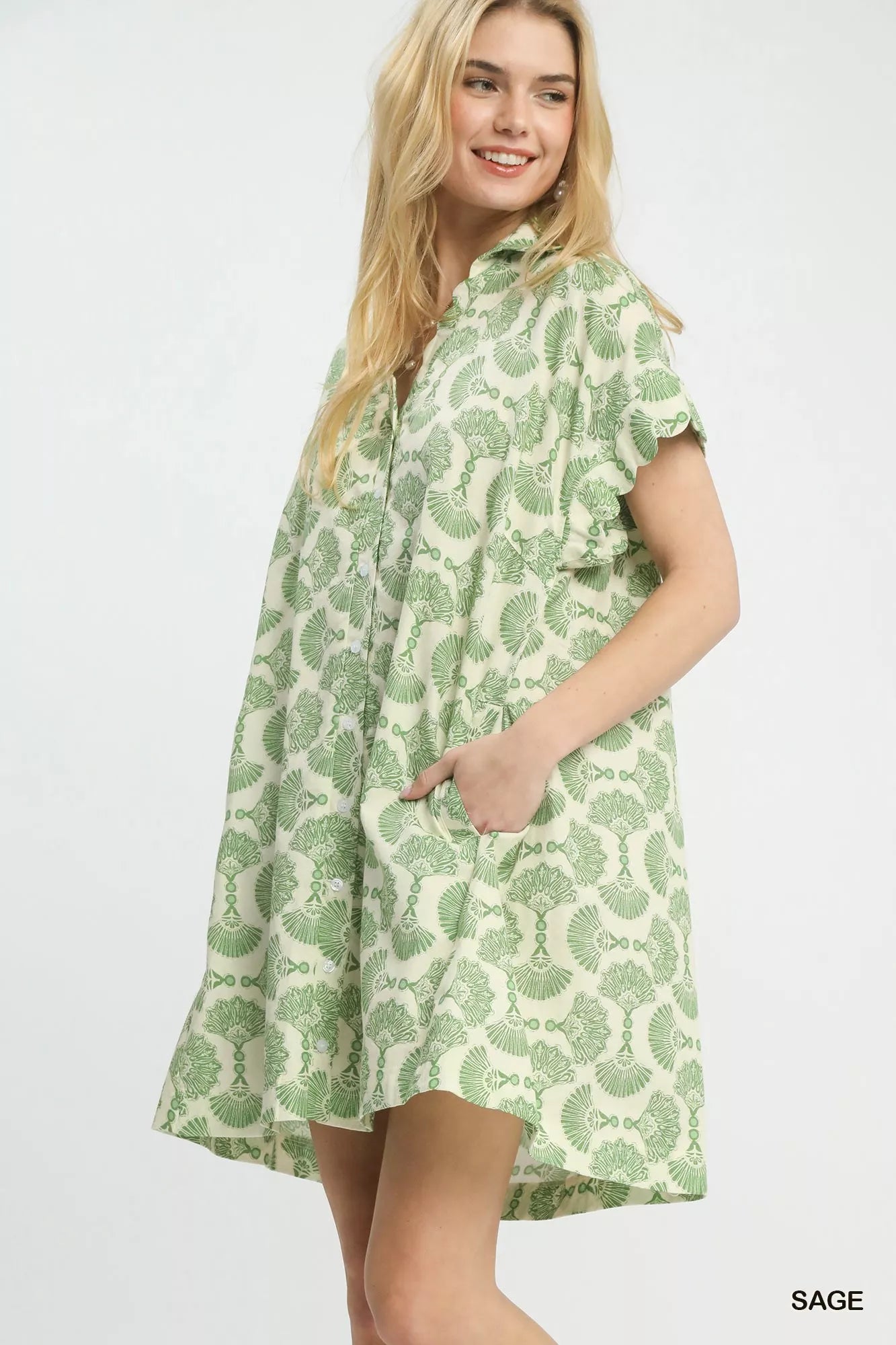 Woman wearing a green patterned dress on a white background