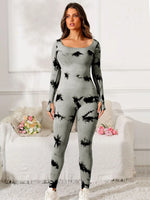 Woman wearing a gray and black tie-dye outfit in a living room setting.