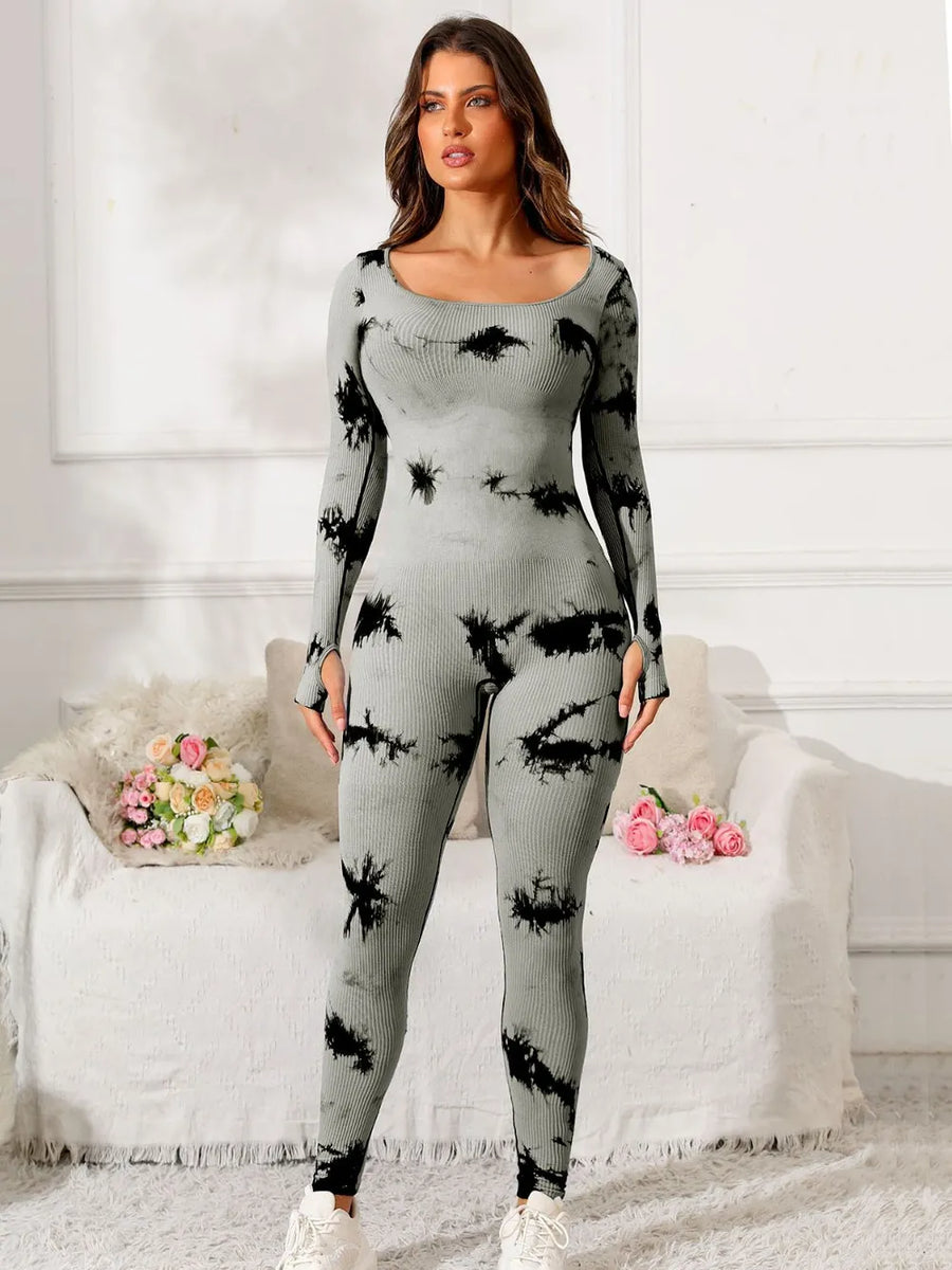 Woman wearing a gray and black tie-dye outfit in a living room setting.