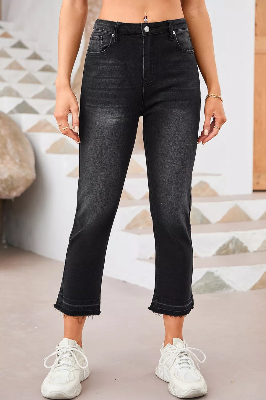 Person wearing black jeans and white sneakers in a casual setting