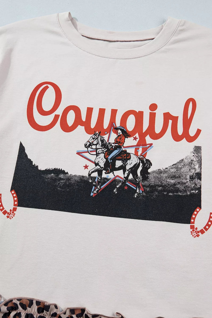 Light-colored sweatshirt with 'Cowgirl' graphic design featuring a rider on a horse.