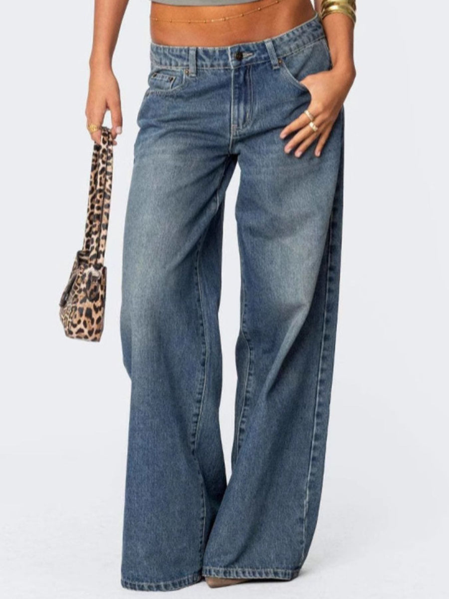 Person wearing blue jeans with a leopard print handbag on a white background