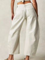 Person wearing light-colored wide-leg jeans on a plain background