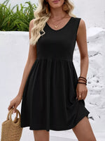 Woman wearing a black sleeveless dress with a white background