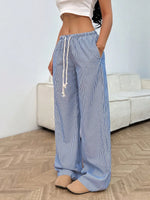 Person wearing blue striped pajama pants in a living room setting.
