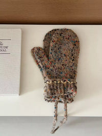 Knitted mitten with colorful pattern on a white surface