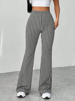 Houndstooth patterned pants worn by a person on a plain background