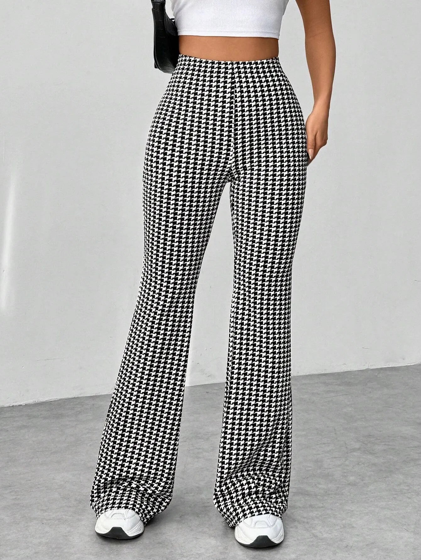 Houndstooth patterned pants worn by a person on a plain background