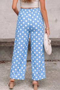 Person wearing blue polka dot pants with a neutral background