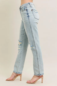Light blue jeans with slight distressing on a plain background