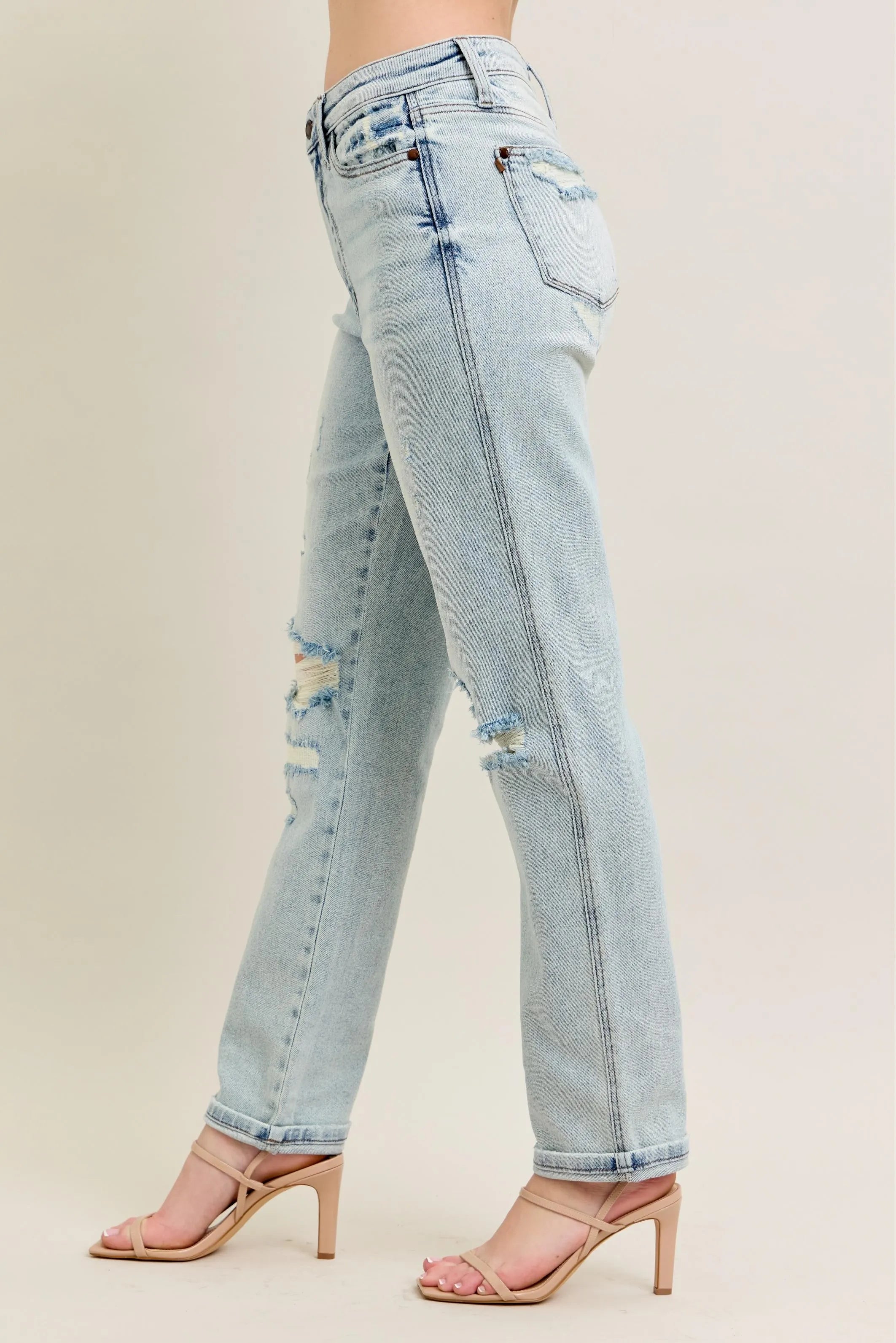 Light blue jeans with slight distressing on a plain background