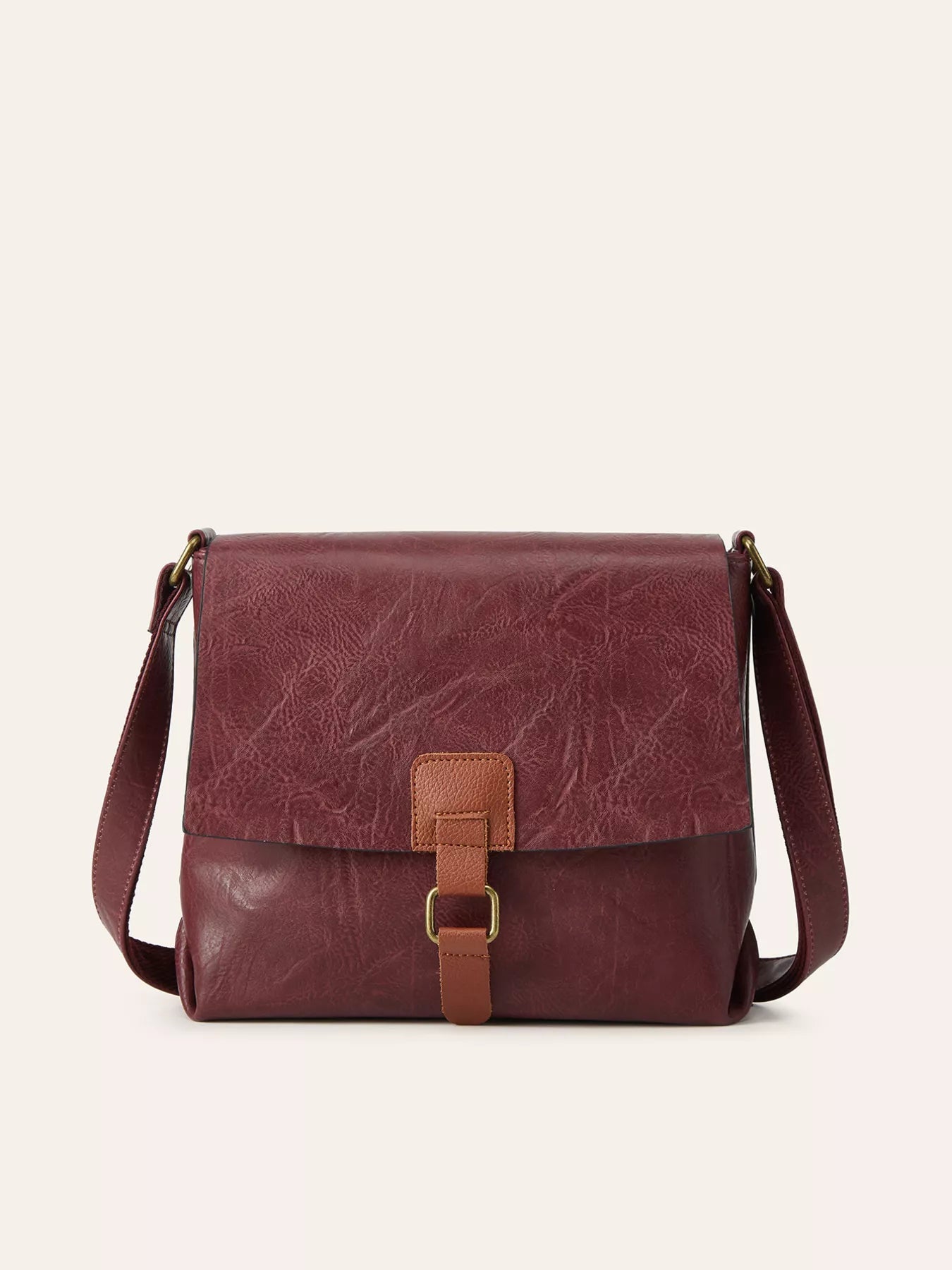 Brown leather bag with a strap on a white background