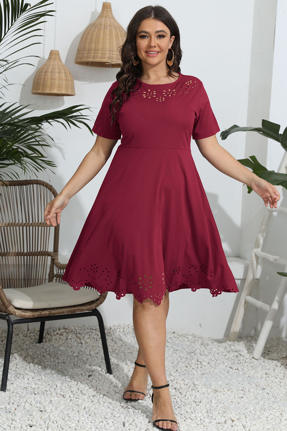 Woman wearing a red dress with lace details in an indoor setting.